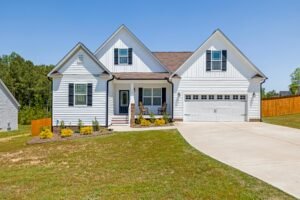 Fresh Home (Sample) Modern white family home with garage, front yard, and blue sky background.